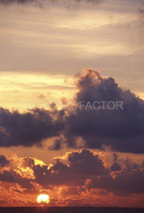 Islands;sunsets;sky;clouds;colorful;blue water;sun;yellow;red;pink;sillouettes;blue;maldive island